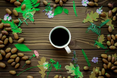 white ceramic mug on purple and white leaves
